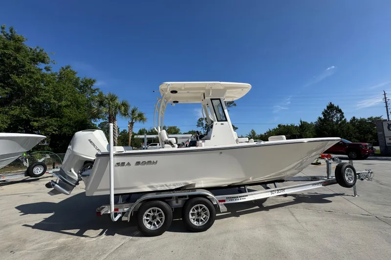 Slide: The Image of 2027 Sea Born LX22 Center Console boat on trailer under clear blue sky. - 8