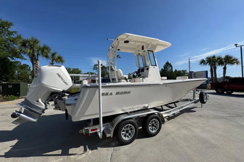 Slide: The Image of 2027 Sea Born LX22 Center Console boat on trailer, parked outdoors under clear blue sky. - 9