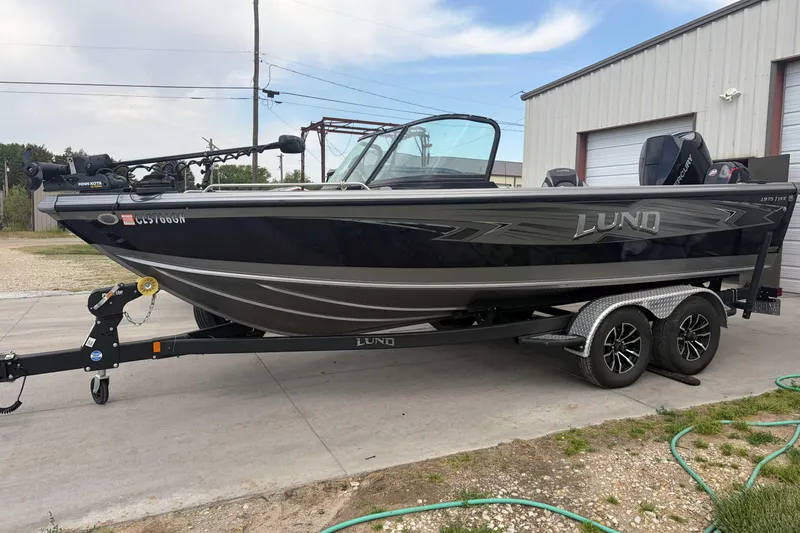 The Image of 2023 Lund 1975 Tyee boat on trailer, parked outside a building. - 0