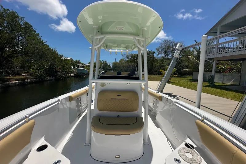Slide: The Image of 2021 Sportsman Open 232 Center Console boat docked, featuring tan seating and a sleek design. - 22