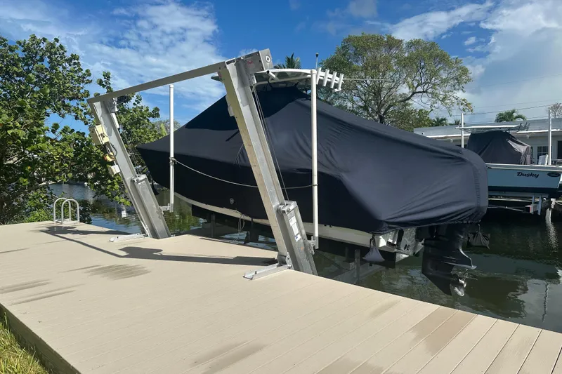 Slide: The Image of 2021 Sportsman Open 232 Center Console boat covered on a lift by the dock. - 25
