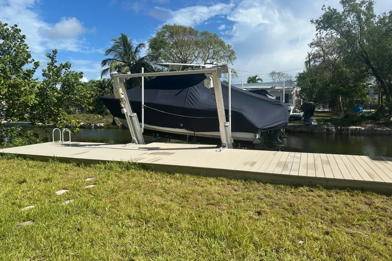Slide: The Image of 2021 Sportsman Open 232 Center Console boat covered on a dock by a canal. - 26