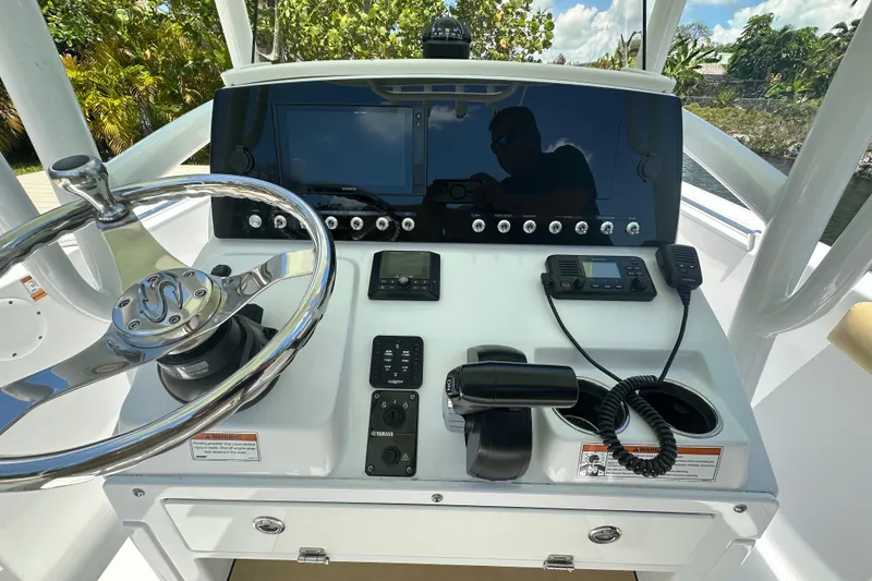 Slide: The Image of 2021 Sportsman Open 232 Center Console boat dashboard with steering wheel and navigation controls. - 32