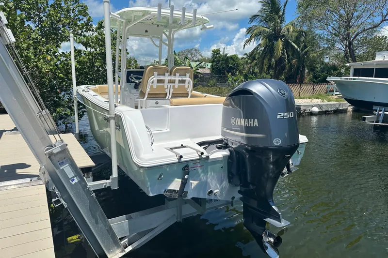Slide: The Image of 2021 Sportsman Open 232 Center Console boat with Yamaha 250 engine docked by water. - 38