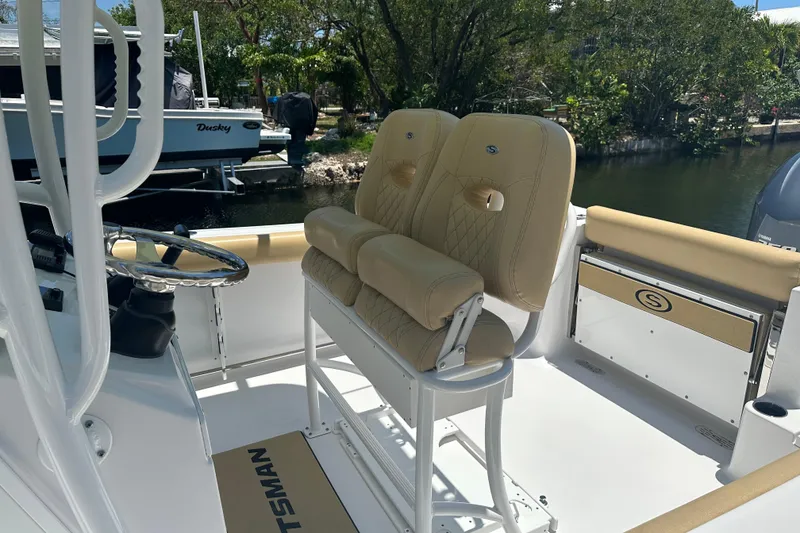 Slide: The Image of 2021 Sportsman Open 232 Center Console boat interior with beige seating and steering wheel. - 40