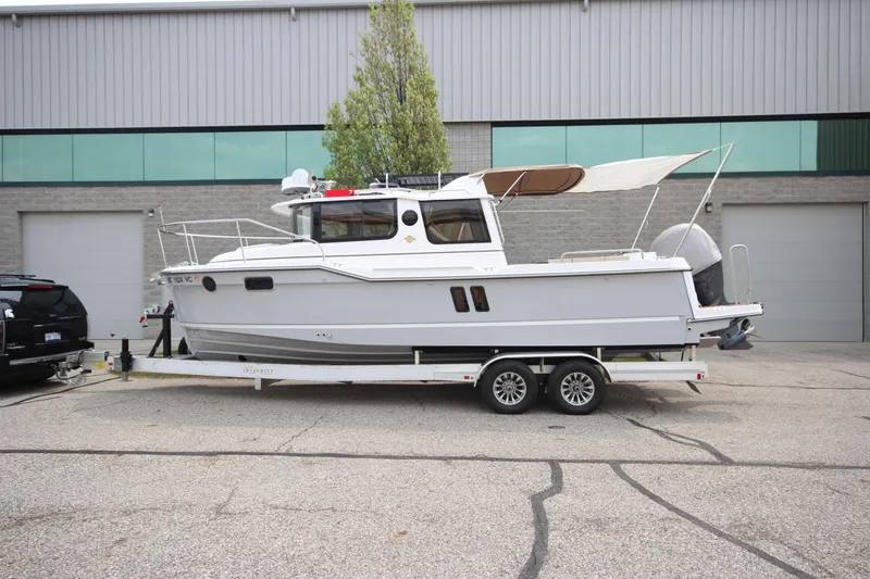 The Image of 2025 Ranger Tugs R-25 boat on trailer, parked outside industrial building. - 1
