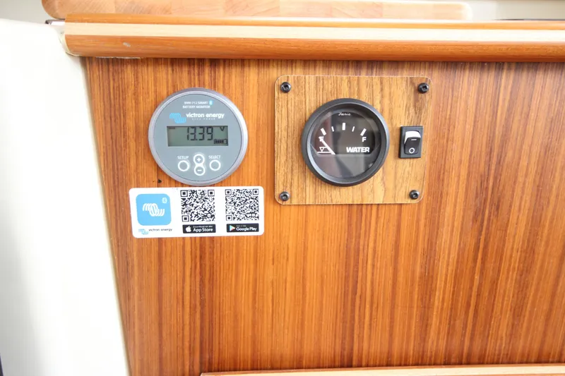 Slide: The Image of 2025 Ranger Tugs R-25 control panel with battery and water level gauges. - 21