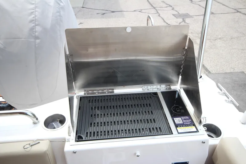 Slide: The Image of Outdoor grill on 2025 Ranger Tugs R-25 boat, featuring stainless steel design and protective cover. - 47