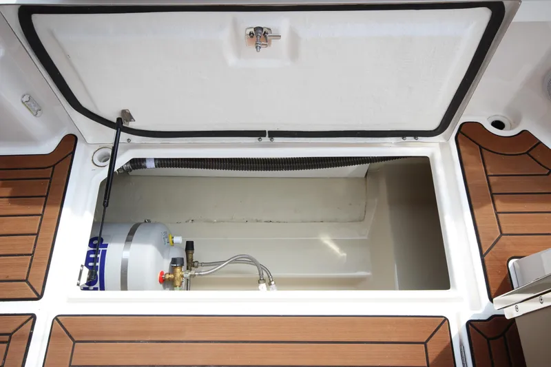 Slide: The Image of Open storage compartment on 2025 Ranger Tugs R-25 boat, featuring a water heater. - 49