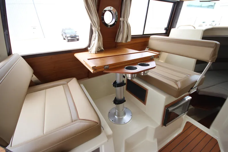 Slide: The Image of Interior of 2025 Ranger Tugs R-25 boat with seating and wooden table. - 62