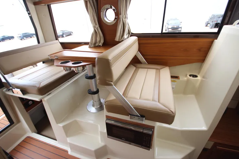 Slide: The Image of Interior of 2025 Ranger Tugs R-25 with beige seating and wooden accents. - 63