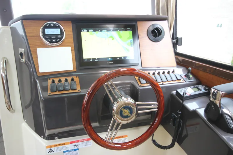 Slide: The Image of Helm of 2025 Ranger Tugs R-25 with navigation display and wooden steering wheel. - 64