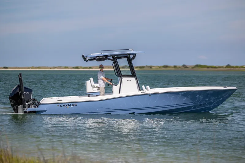 Slide: The Image of 2026 Caymas 281 HB boat cruising on calm waters with a person at the helm. - 1