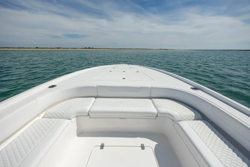 Slide: The Image of 2026 Caymas 281 HB boat with white seating, cruising on open water under a clear sky. - 11