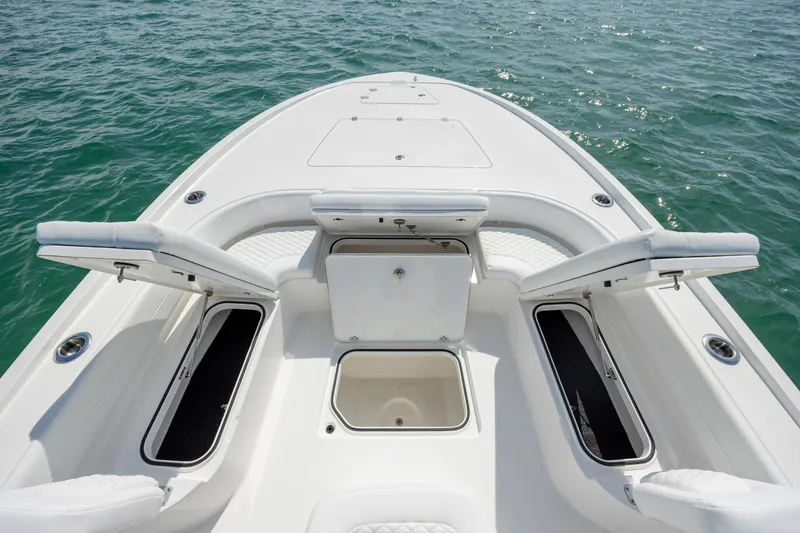 Slide: The Image of 2026 Caymas 281 HB boat deck with open storage compartments on calm water. - 14