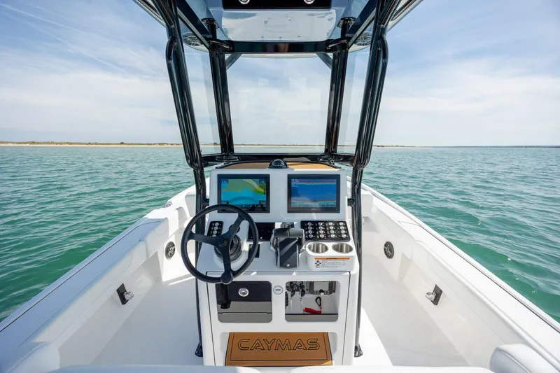 Slide: The Image of 2026 Caymas 281 HB boat dashboard with steering wheel and navigation screens on open water. - 20