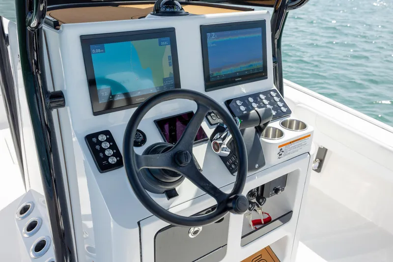 Slide: The Image of 2026 Caymas 281 HB boat dashboard with steering wheel and navigation screens. - 24