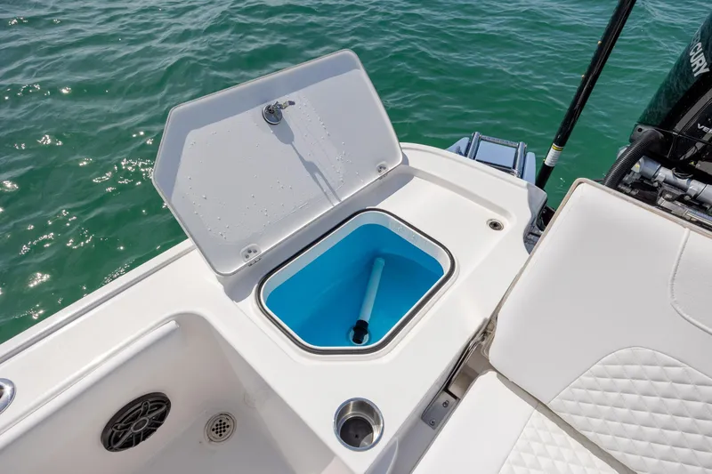 Slide: The Image of 2026 Caymas 281 HB boat with open storage compartment on deck, near water. - 29