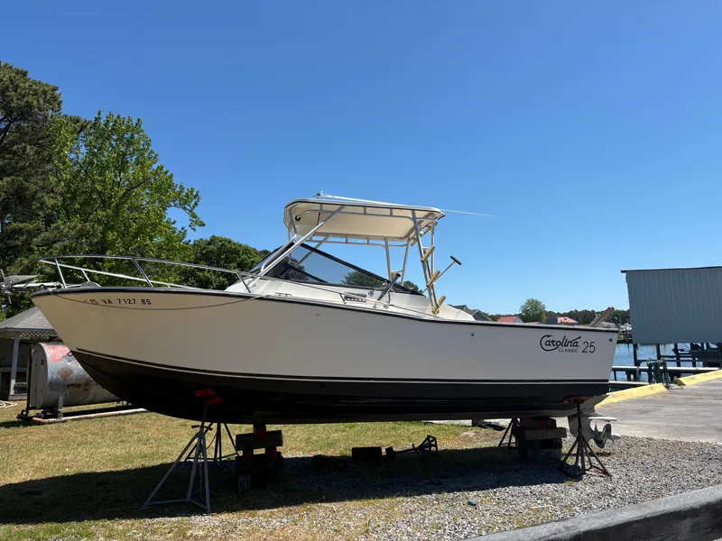 Slide: The Image of 1996 Carolina Classic 25 Express boat on stands outdoors. - 1