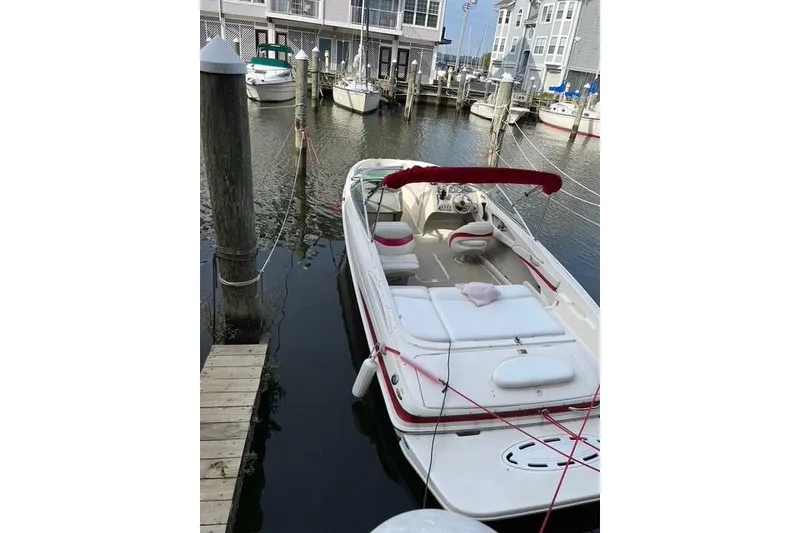 Slide: The Image of 2004 Maxum 2200 SR3 boat docked in a marina with red canopy. - 2