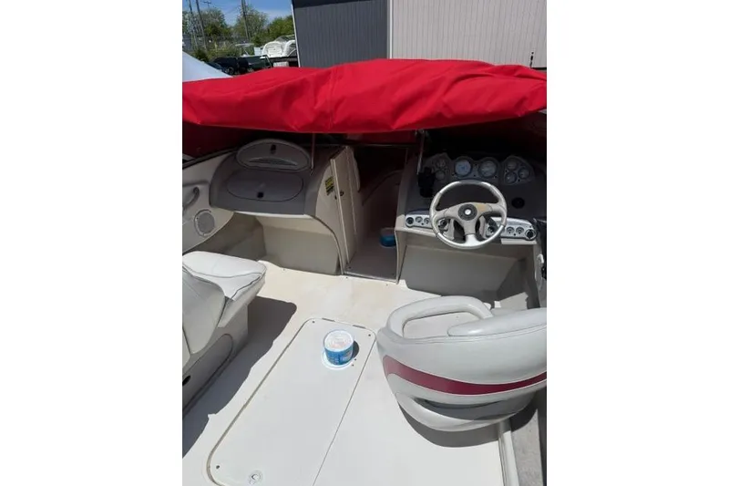 Slide: The Image of 2004 Maxum 2200 SR3 boat interior with red cover and steering wheel. - 3