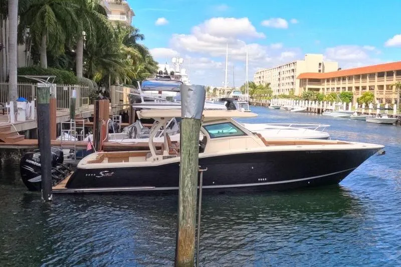 The Image of 2018 Scout 380 LXF boat docked in a scenic marina setting. - 1