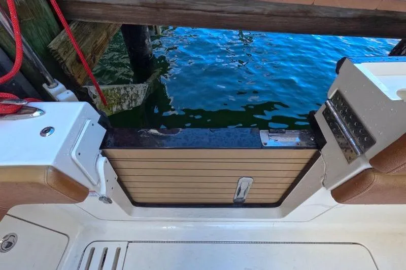 Slide: The Image of 2018 Scout 380 LXF boat deck with water view and wooden accents. - 5