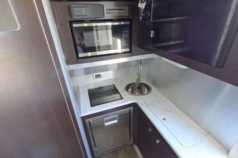 Slide: The Image of Compact kitchen area in a 2018 Scout 380 LXF boat with modern appliances. - 8