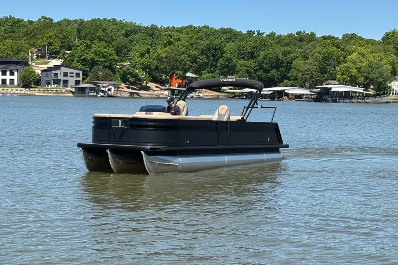 Slide: The Image of 2026 Viaggio Z24U pontoon boat cruising on a scenic lake with lush green shoreline. - 7