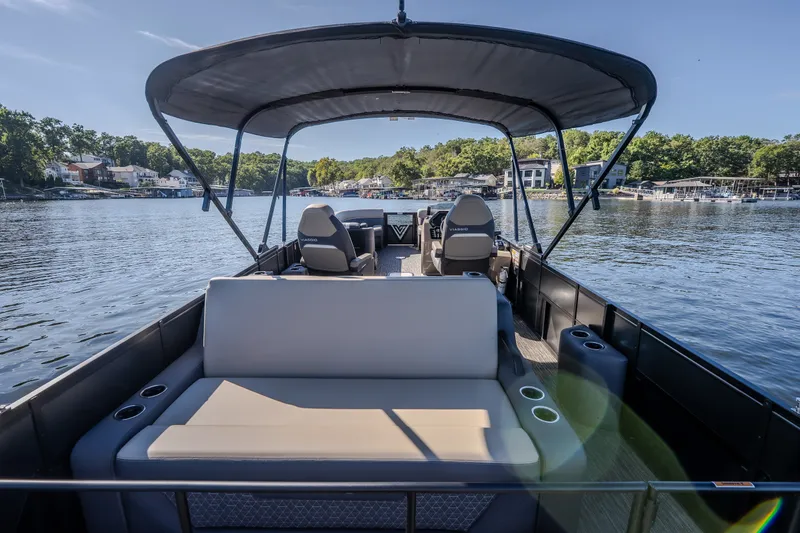 Slide: The Image of 2026 Viaggio Z24S pontoon boat on a serene lake with canopy and seating. - 15