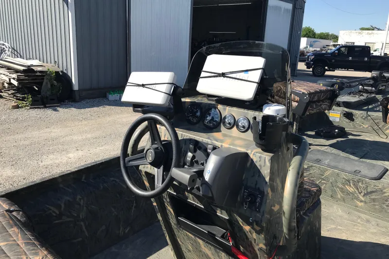 Slide: The Image of 2015 War Eagle 961 Blackhawk boat dashboard with steering wheel and navigation equipment. - 13