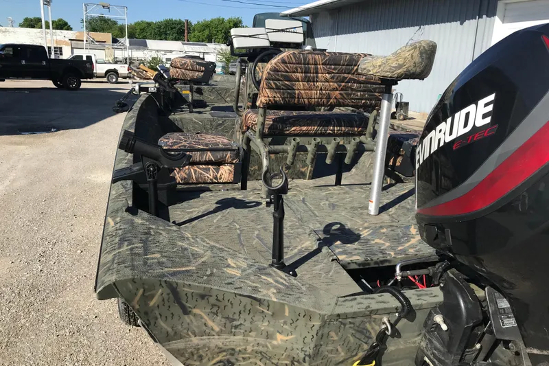 Slide: The Image of 2015 War Eagle 961 Blackhawk boat with camo seats and Evinrude motor in a parking lot. - 5