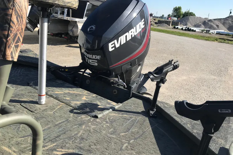 Slide: The Image of War Eagle 961 Blackhawk boat with Evinrude motor, 2015 model, parked outdoors. - 7