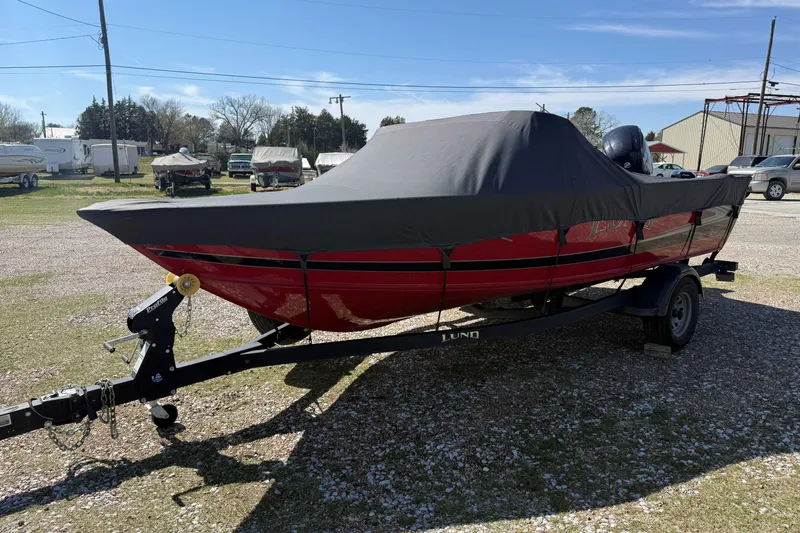 The Image of 2020 Lund 1875 Crossover XS boat with cover on trailer, parked outdoors. - 1