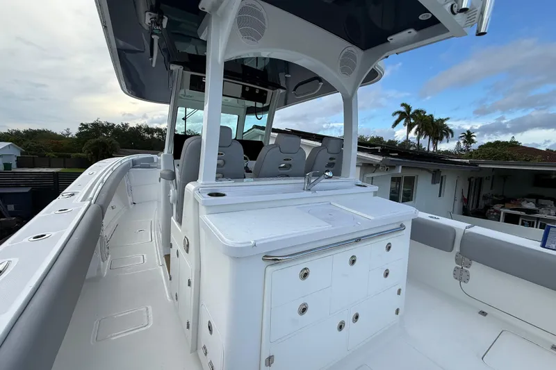 Slide: The Image of 2020 HCB 39 Speciale boat interior with seating and storage, under a cloudy sky. - 14