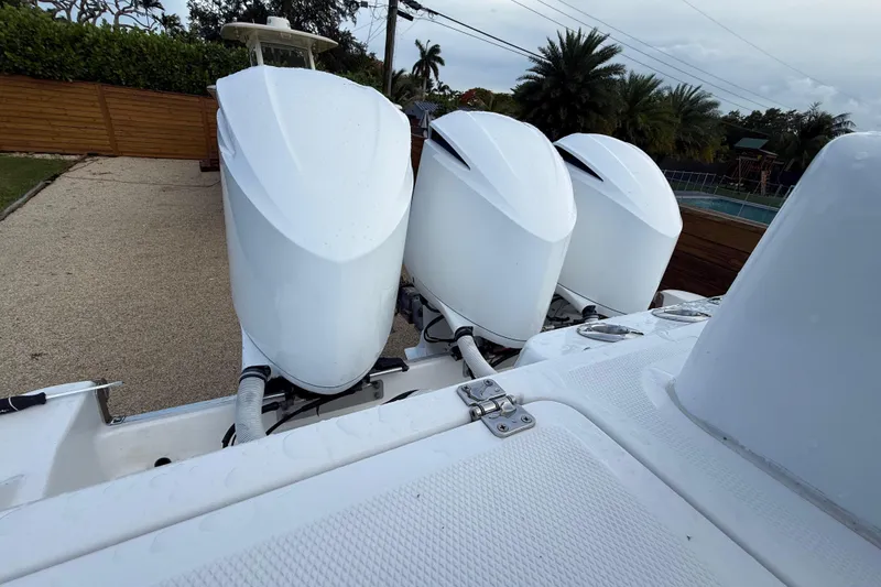 Slide: The Image of Triple outboard engines on a 2020 HCB 39 Speciale boat, parked near a pool. - 16