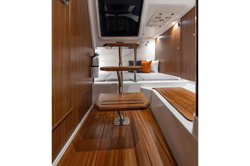 Slide: The Image of Manufacturer Provided Image: Interior of 2025 Pursuit OS 325 Offshore boat with wooden steps and cozy seating area. - 20