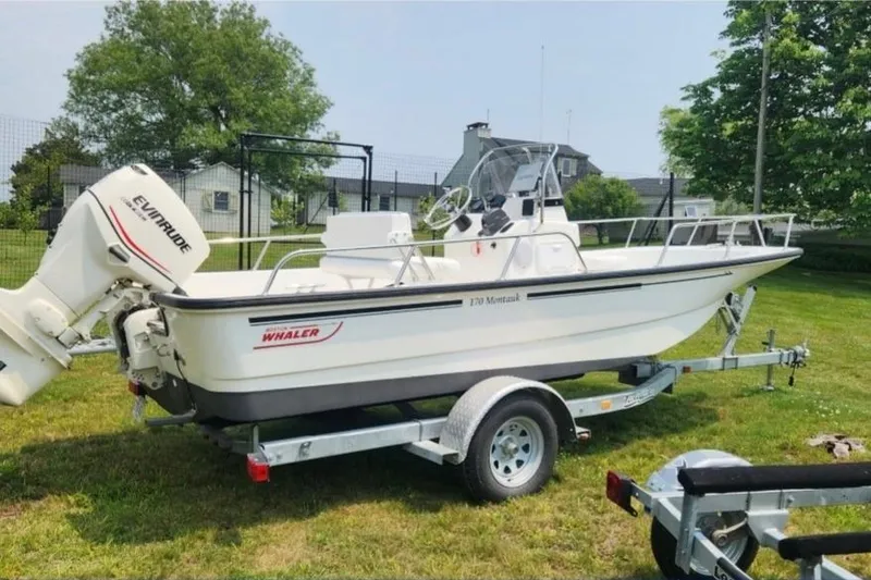 The Image of 2006 Boston Whaler 170 Montauk boat on trailer, parked on grass. - 0