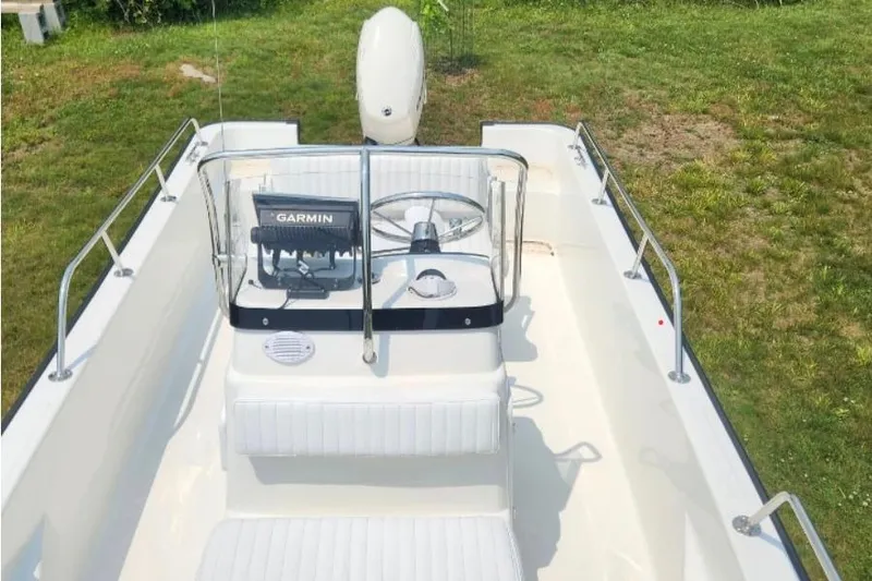 Slide: The Image of 2006 Boston Whaler 170 Montauk boat interior with Garmin navigation system, parked on grass. - 4