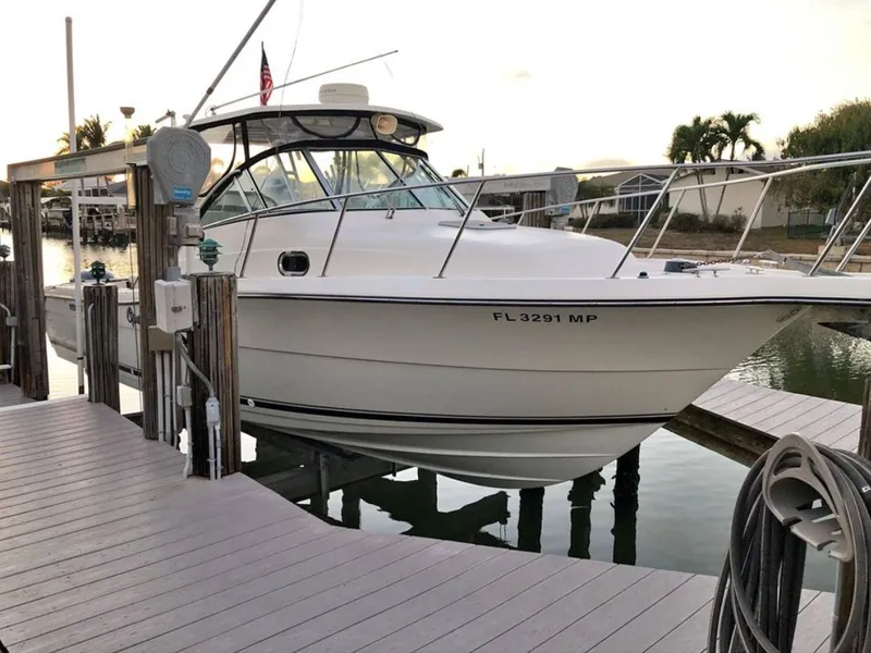 The Image of 2004 Pursuit 3070 Offshore boat docked at sunset. - 0