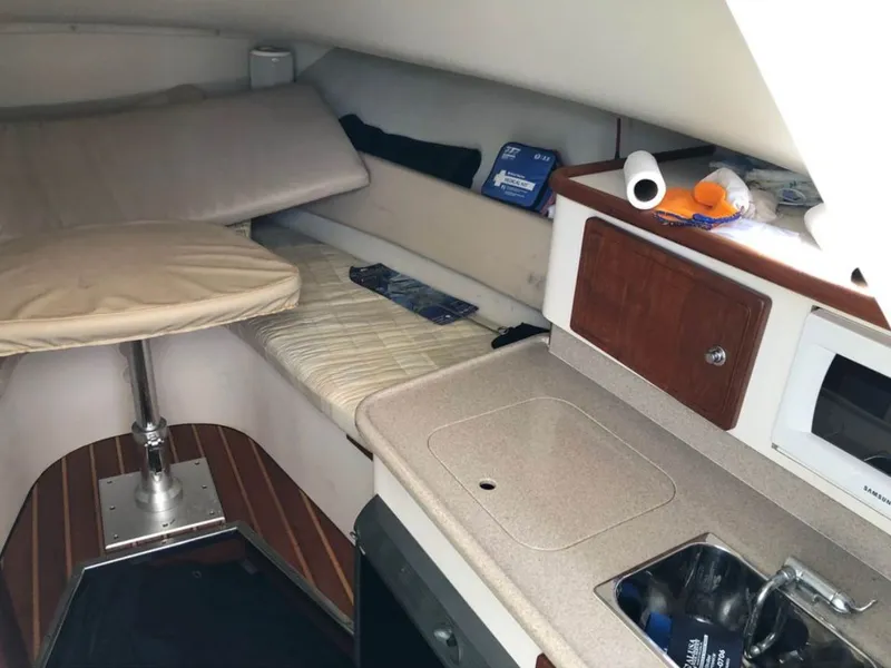 Slide: The Image of Interior of a 2004 Pursuit 3070 Offshore with kitchenette and sleeping area. - 15