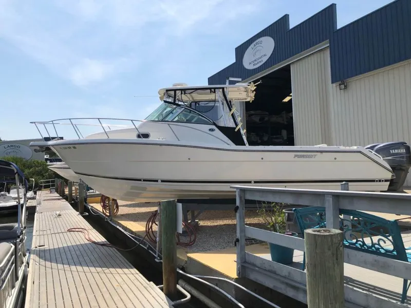 Slide: The Image of 2004 Pursuit 3070 Offshore boat docked near warehouse. - 2