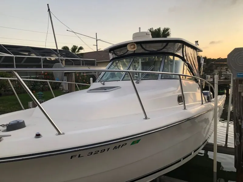 Slide: The Image of 2004 Pursuit 3070 Offshore boat docked at sunset. - 6
