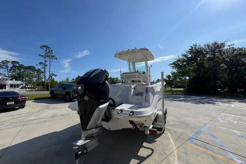 Slide: The Image of 2026 Sailfish 232 CC boat with outboard motor in a sunny parking lot. - 11