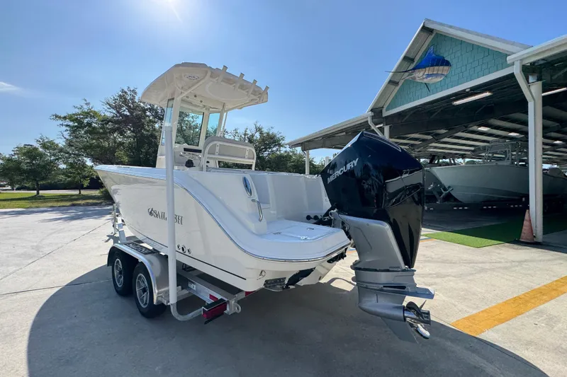 Slide: The Image of 2026 Sailfish 232 CC boat with Mercury engine on trailer, parked outdoors. - 13