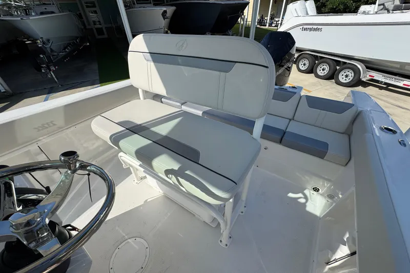 Slide: The Image of 2026 Sailfish 232 CC boat interior with cushioned seating and steering wheel. - 24