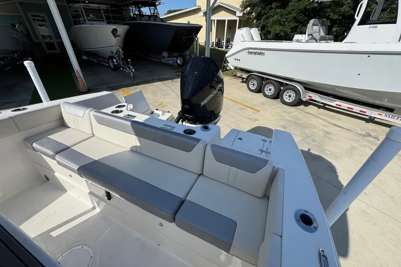 Slide: The Image of 2026 Sailfish 232 CC boat interior with seating and outboard motor in a marina setting. - 33