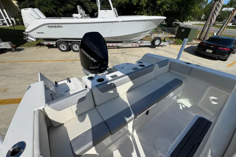Slide: The Image of 2026 Sailfish 232 CC boat interior with Mercury engine, parked near Everglades boat on trailer. - 35