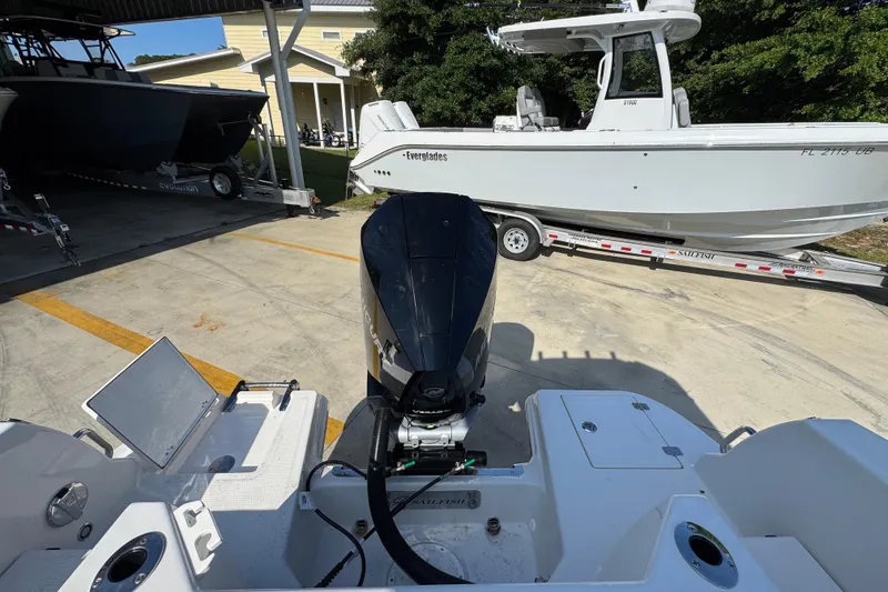 Slide: The Image of 2026 Sailfish 232 CC boat with outboard motor, parked on a trailer. - 36