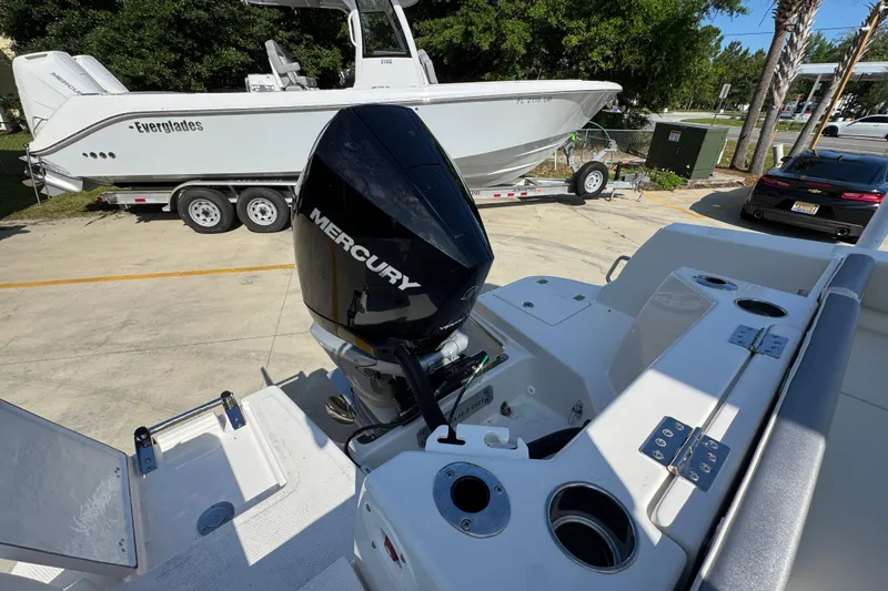 Slide: The Image of 2026 Sailfish 232 CC boat with Mercury engine, parked near Everglades boat on trailer. - 38